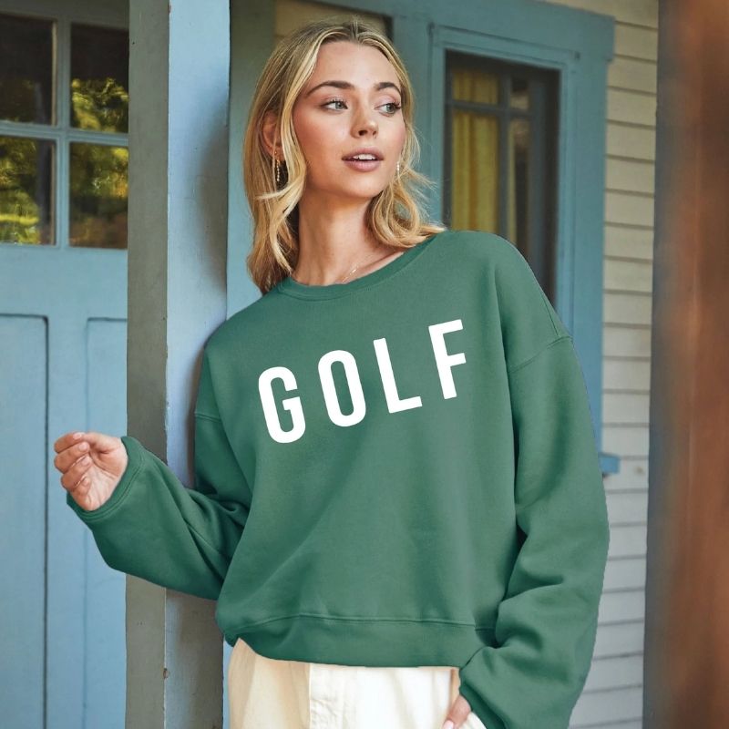 A green cropped fleece pullover with long sleeves and bold GOLF graphic on the front, displayed on a white background.